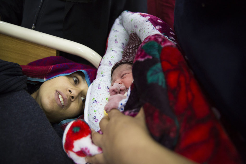 A mother meets her newborn baby at the high-risk postnatal ward after suffering from postpartum haemorrhaging during labour. Holy Family Hospital, Rawalpindi.