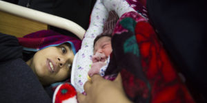 A mother meets her newborn baby at the high-risk postnatal ward after suffering from postpartum haemorrhaging during labour. Holy Family Hospital, Rawalpindi.