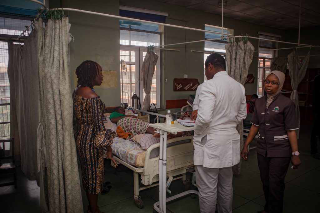 Professor Nike Bello examines a pregnant patient in a hospital bed in Ibadan, Nigeria.
