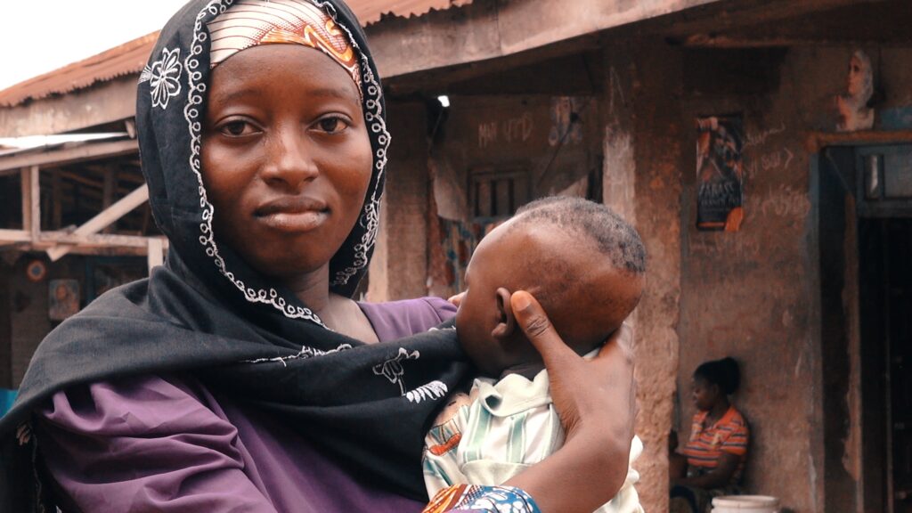 A woman holds a baby close to her chest.